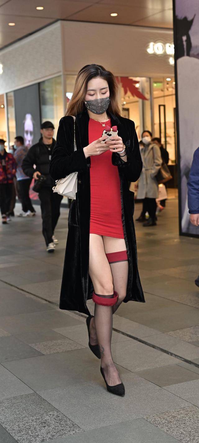 红色包臀短裙搭配黑丝袜,外穿黑色呢子大衣,十足的御姐范儿