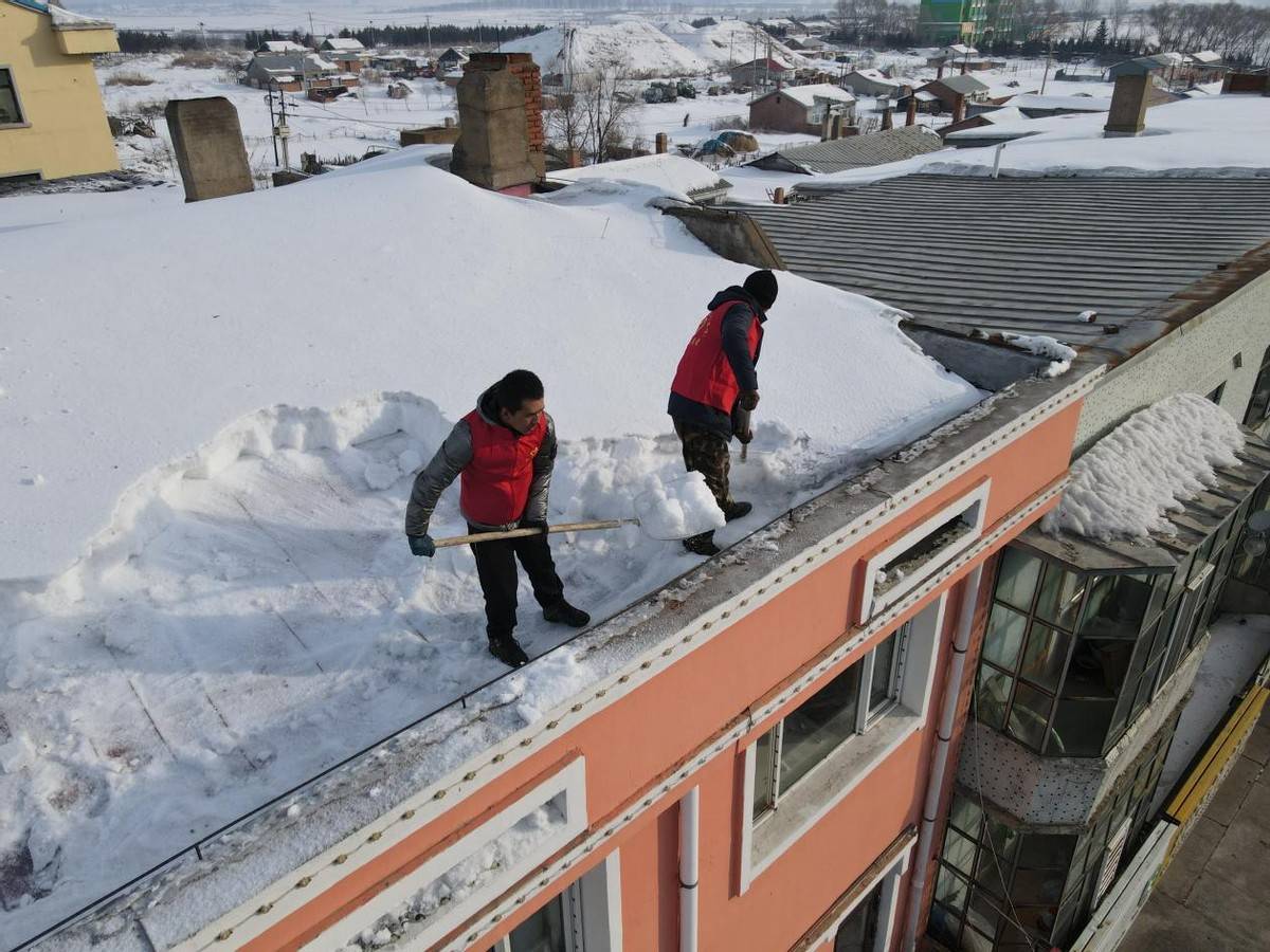 黑龙江红光农场有限公司团委组织志愿者清理楼顶积雪确保职工出行安全