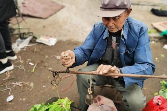 不过九十岁的老爷子,还延续着过去摆摊的老传统,收现金,用杆秤,很有旧