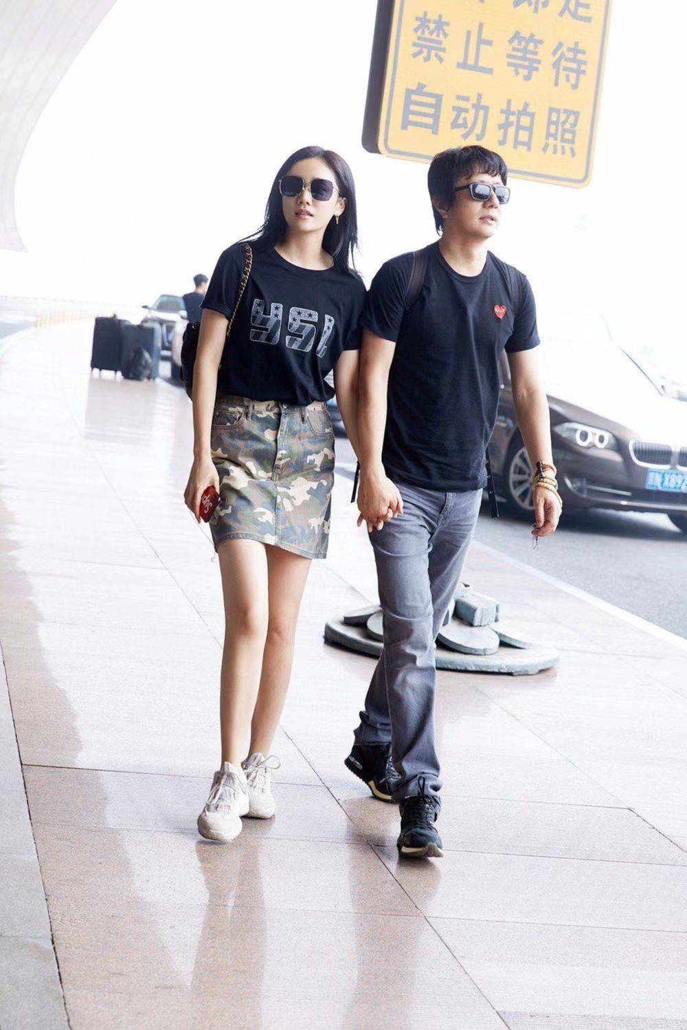 原创54岁郑钧好热情与小16岁娇妻在机场热吻剪齐刘海刻意扮嫩