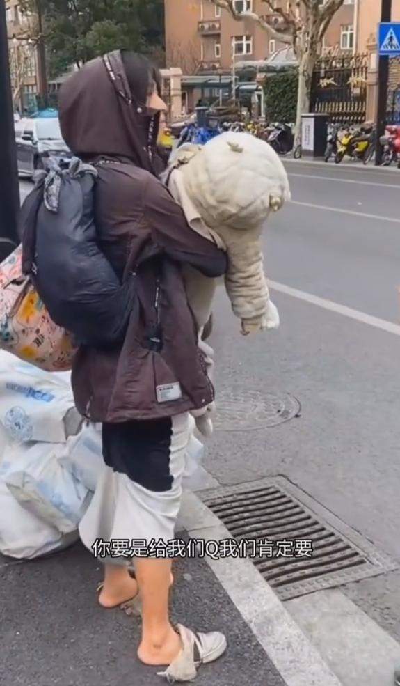 上海一女子怀抱幼儿流浪街头大热天孩子还穿着棉袄网友心疼