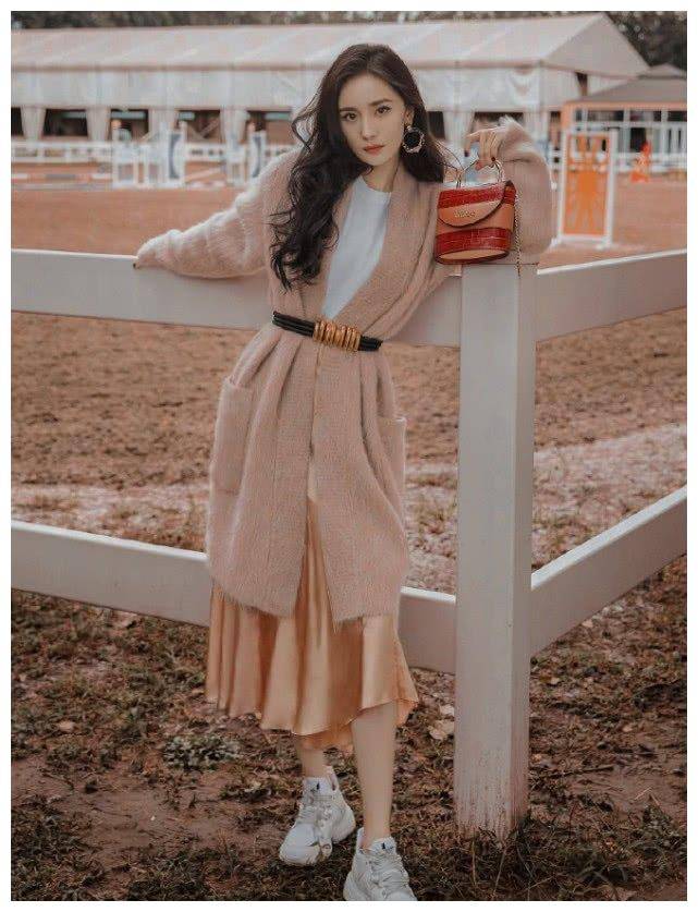 拍摄的杨幂全身穿搭极具秋冬气息,卡其色开衫内搭白色t恤,香槟金色