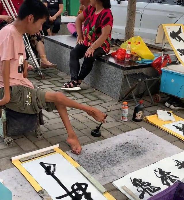 残疾男孩的地摊书法用脚书写字迹洒脱飘逸笔笔惊艳