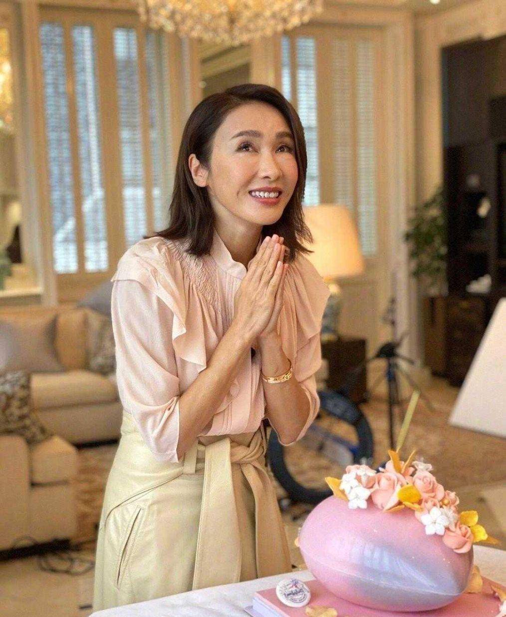 下图照片中,黎姿穿了一件浅粉色衬衫搭配米白色短裙,看起来非常的温柔