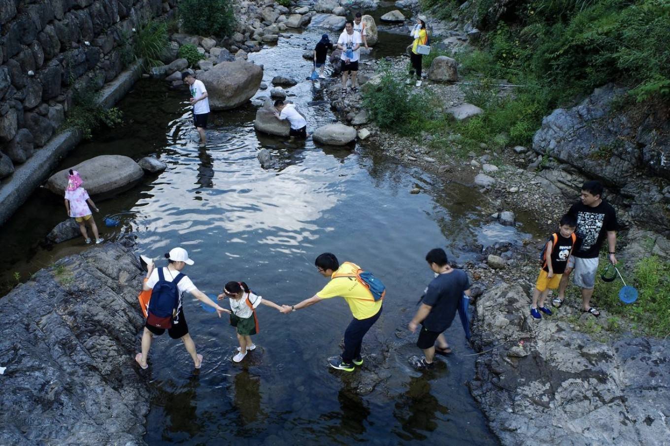 與此同時,小朋友們還沿著黃彈村溪流溯溪了1公里,沿途進行野生技巧