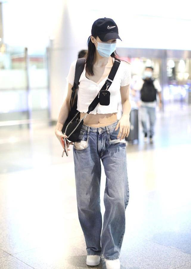 金晨最近的机场造型十分抢眼,露脐t恤搭配宽松牛仔裤,露出她出名的
