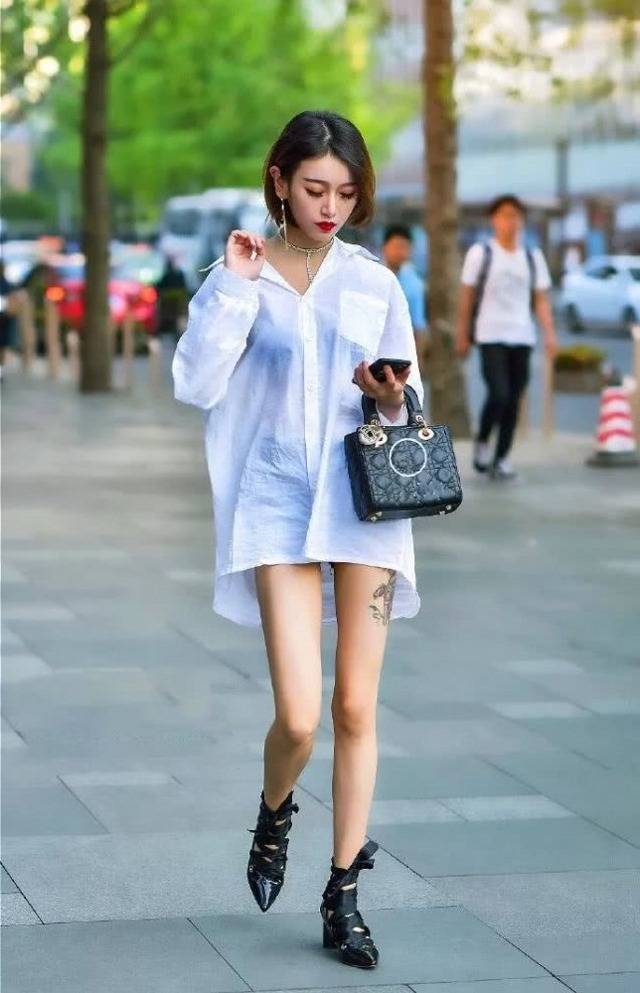 路人街拍,小姐姐光鲜亮丽非常吸睛,穿中长款的衬衫,十分的帅气_感觉