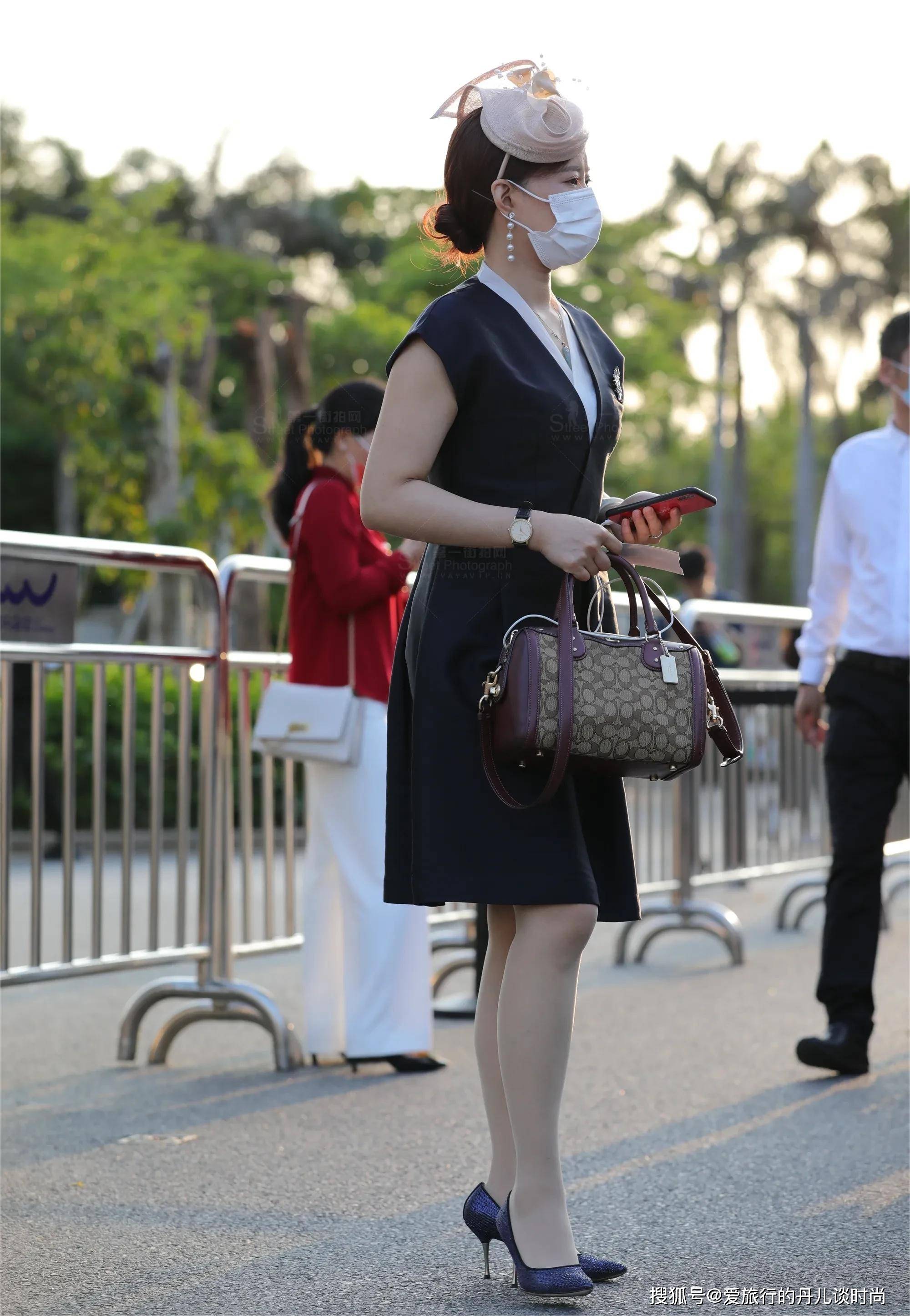 美女一身贵妇打扮,身穿黑色v领收腰连衣裙,手拎紫色手袋很高贵_领口