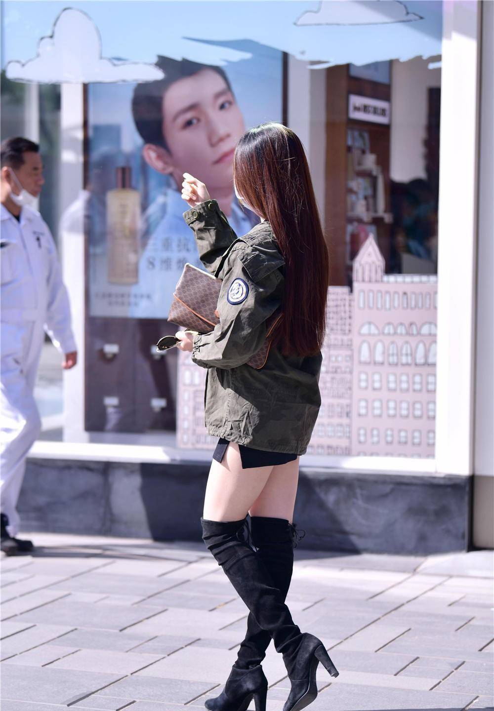 黑色粗跟过膝长靴,搭配黑色短裙,穿着一件墨绿色的外套_风格_美女