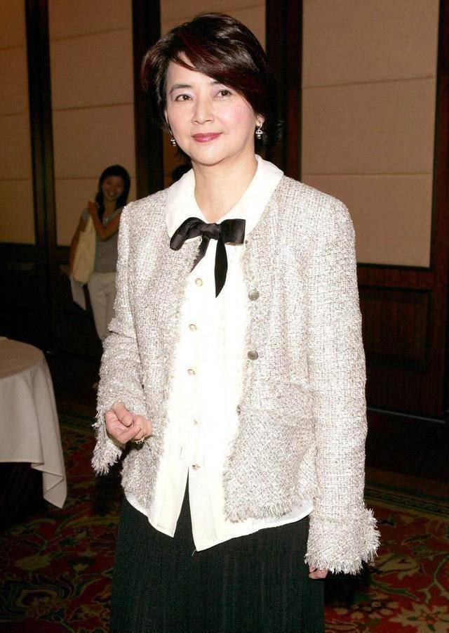 胡慧中胖胖的"贵妇脸",粉红色马甲下身穿小黑裙,一副