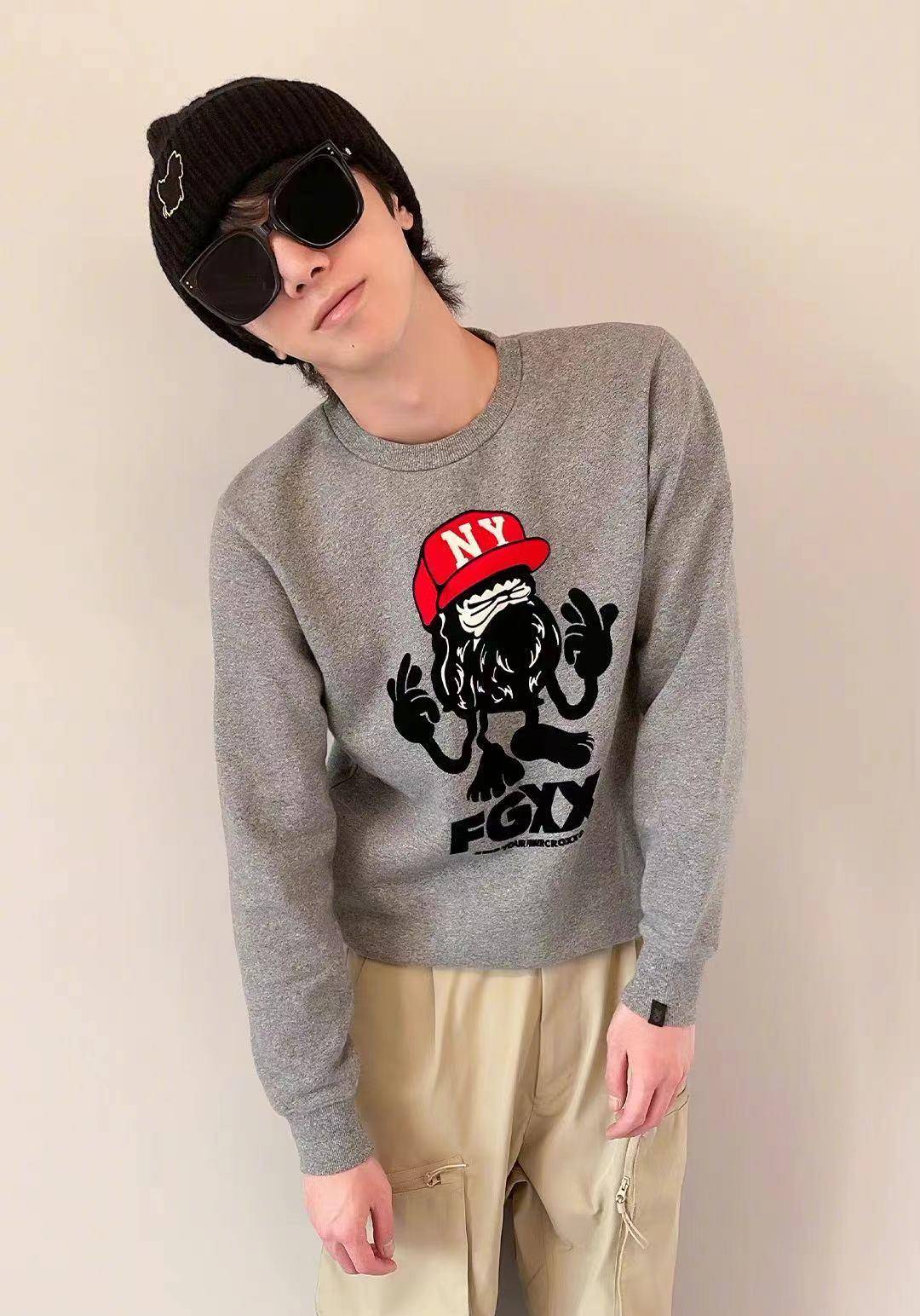只见华晨宇穿着灰色印花卫衣,戴着毛线帽跟墨镜,站在墙前歪头凹造型