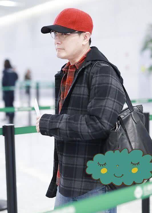 张信哲穿格子夹克配格子衬衫,头上戴小红帽,52岁了也很时髦!