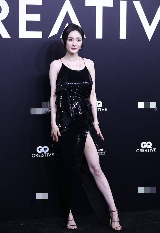 穿黑色吊带长裙,她俏脸清丽,露出白皙的香肩和手臂,一双白嫩的大美腿