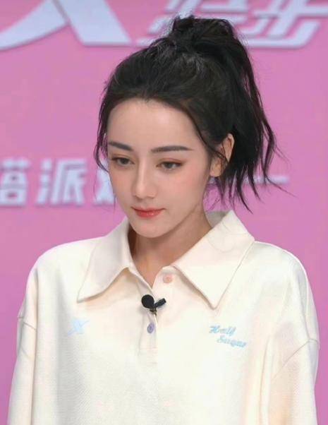 第一套是运动服高马尾造型,迪丽热巴身着米白色polo领短袖,马尾高高的