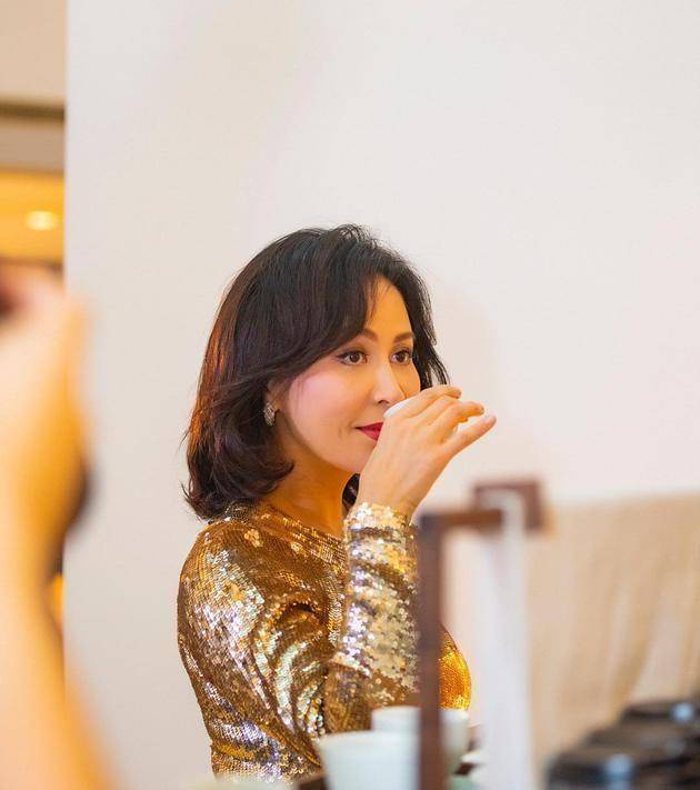 55岁刘嘉玲素颜赏樱,穿卡通卫衣配健美裤,戴大红帽拍游客嗅花照_造型