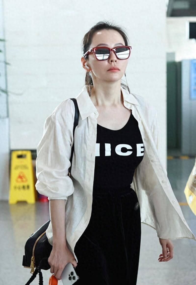 街拍:张靓颖白色外衫内搭黑色长裙酷爽简约 现身北京机场