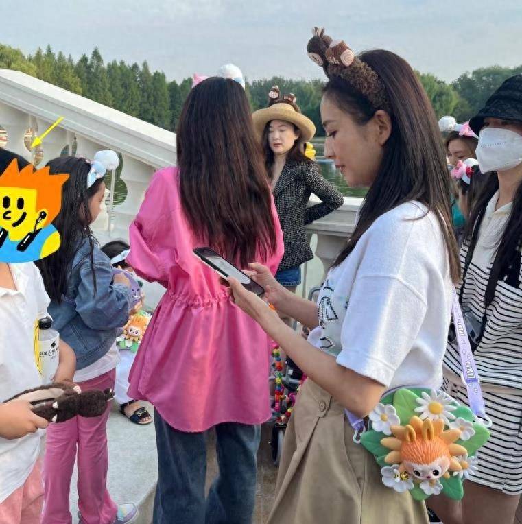 当天,佟丽娅的儿子朵朵身穿白色卡通t恤,下搭粉色裤子,戴着与佟丽娅