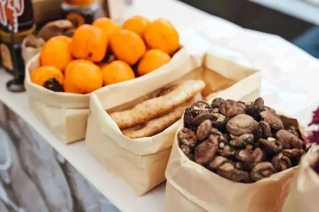 清晨刚采回的新鲜菌菇,柿子和土豆被整齐地码放在桌子上,娃娃鱼在脚底