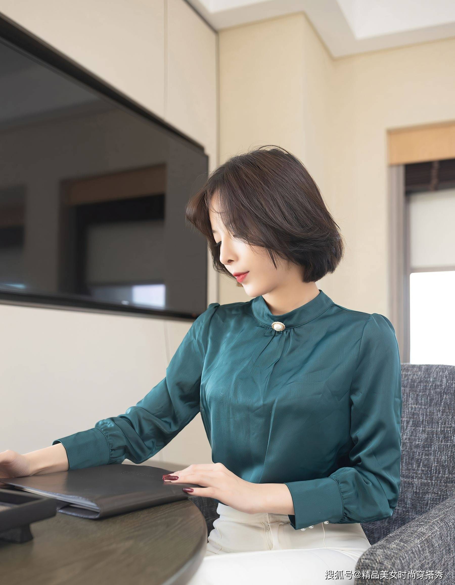 短发美女身着精致的墨绿色衬衫,与黑色高跟鞋相搭配,优雅干练_女性
