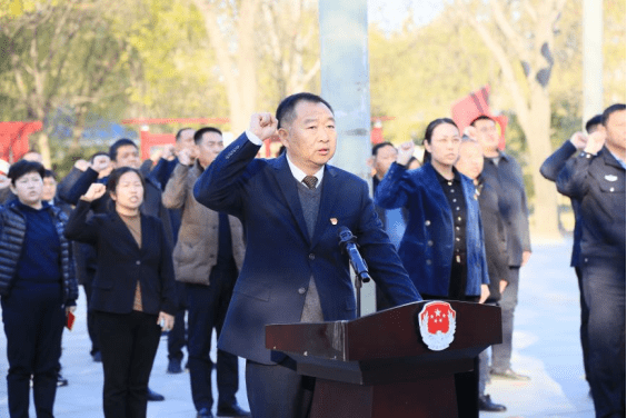 县委副书记,县长李中耀左手抚按《中华人民共和国宪法》,右手举拳,领