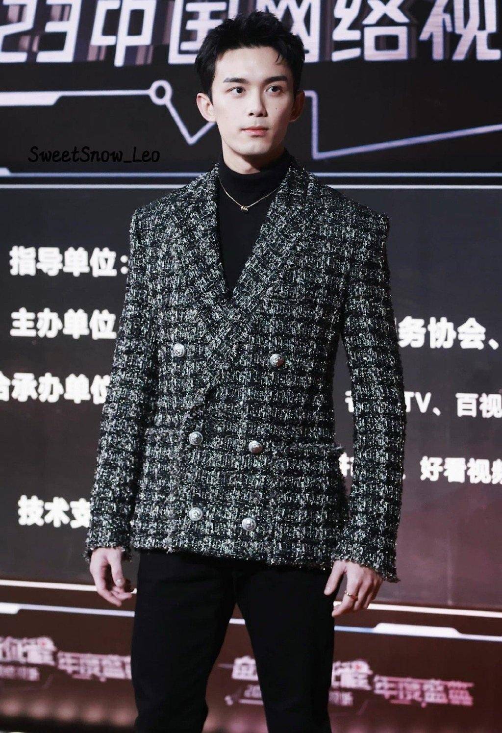 吴磊里面穿黑色高领毛衣,外面搭配黑白格纹西装,下身穿着黑色紧身裤