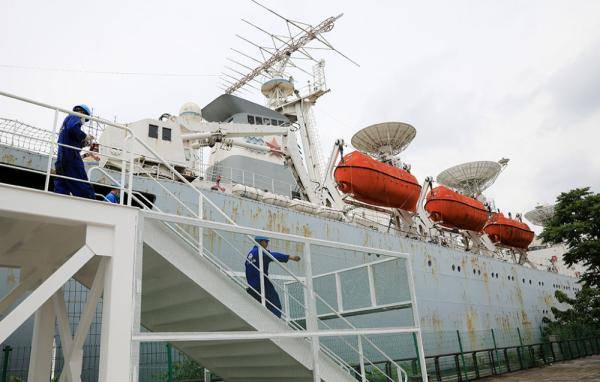5月15日,维修工人走在搭建在"远望1号"测量船边的扶梯上.