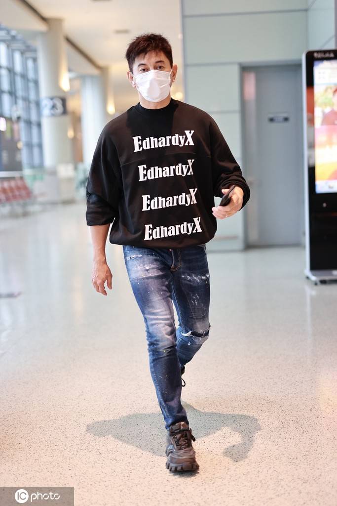 吴奇隆身穿黑色字母t恤搭配蓝色牛仔裤现身机场