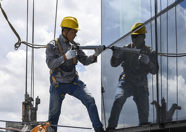 玻璃幕墙打胶施工人员佩戴成华防坠器进行安全保护