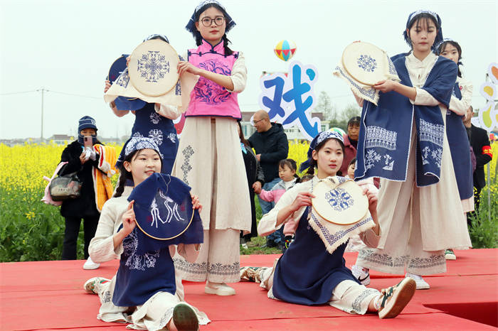 手携古朴典雅的挑花工艺品,在展现国家非遗望江挑花文化魅力的同时