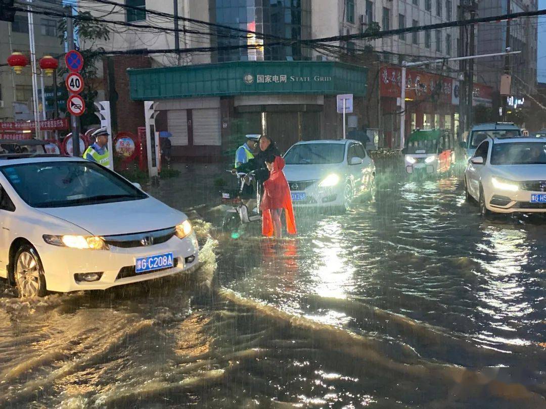 执勤奋战中,民警所穿橄榄绿防水衣已挡不住漫天大雨,全身湿透,脚下