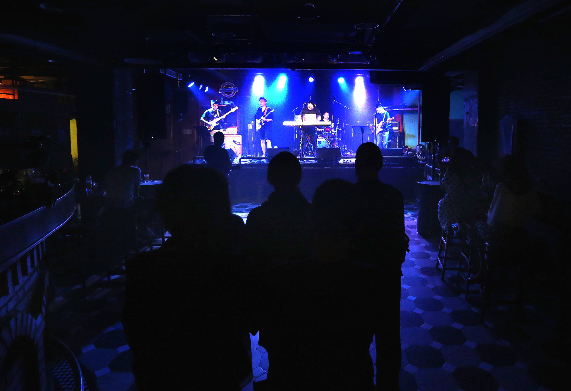 6月15日,游客在上海市愚园路上的一家酒吧欣赏驻唱歌手演唱.