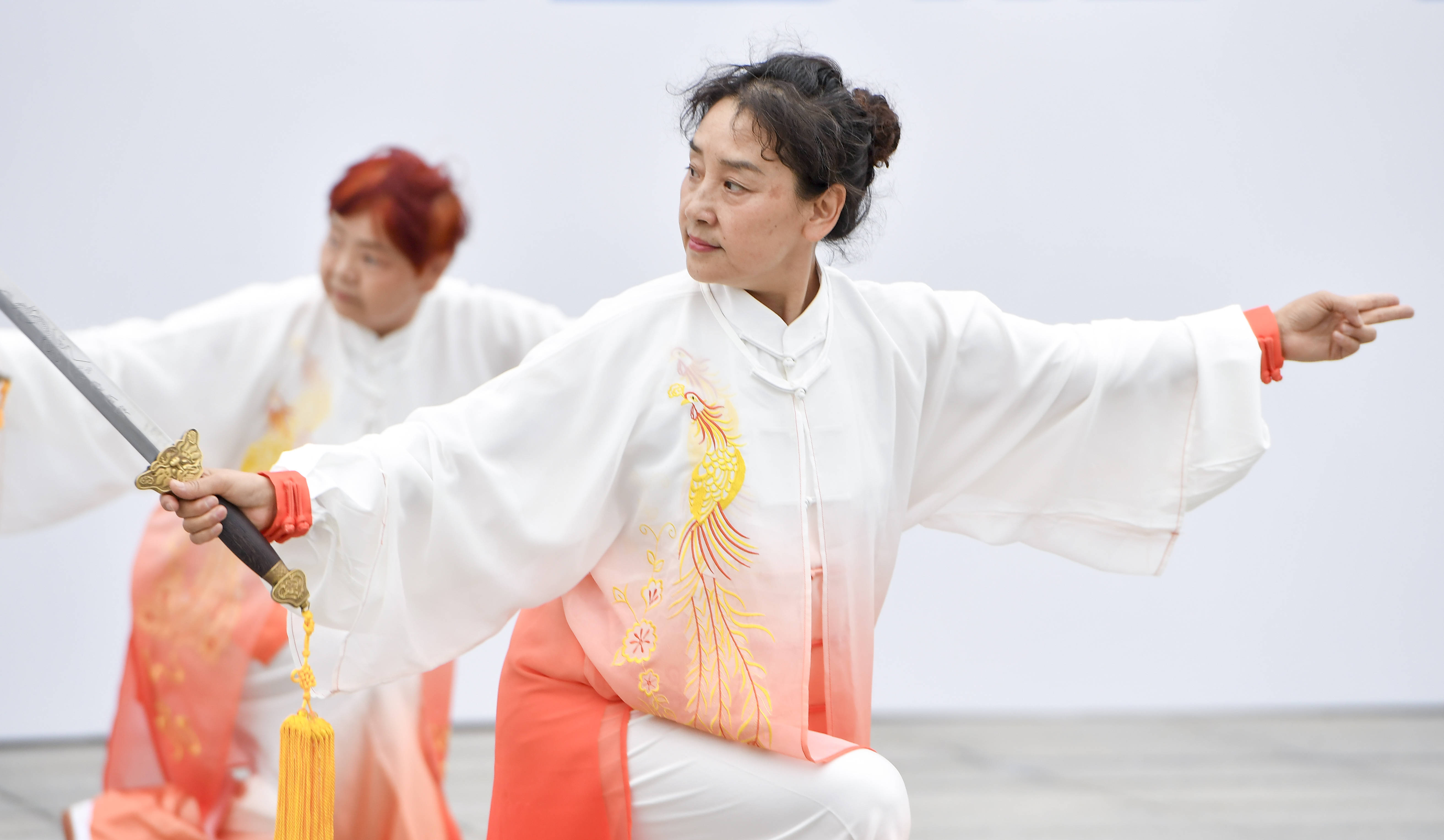 6月23日,在长春体育中心,长春市三佳社区太极剑队的成员进行表演.