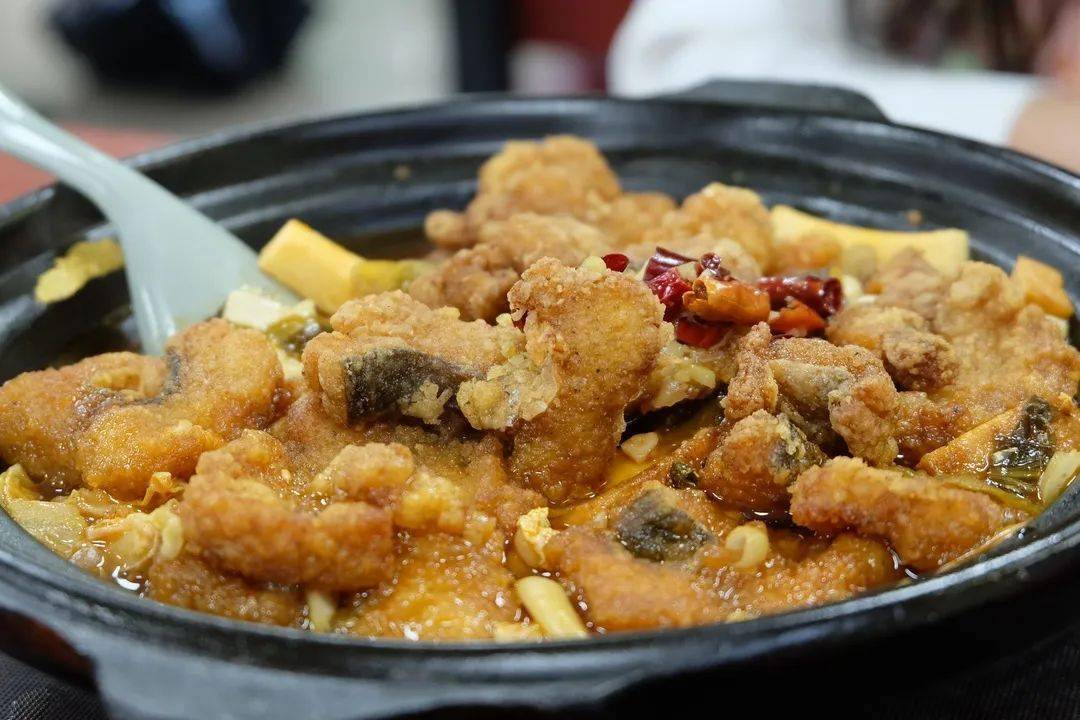 炝锅鱼里刚出锅的炸鱼块盖在豆芽,土豆粉之上呲啦作响等不及放凉就动