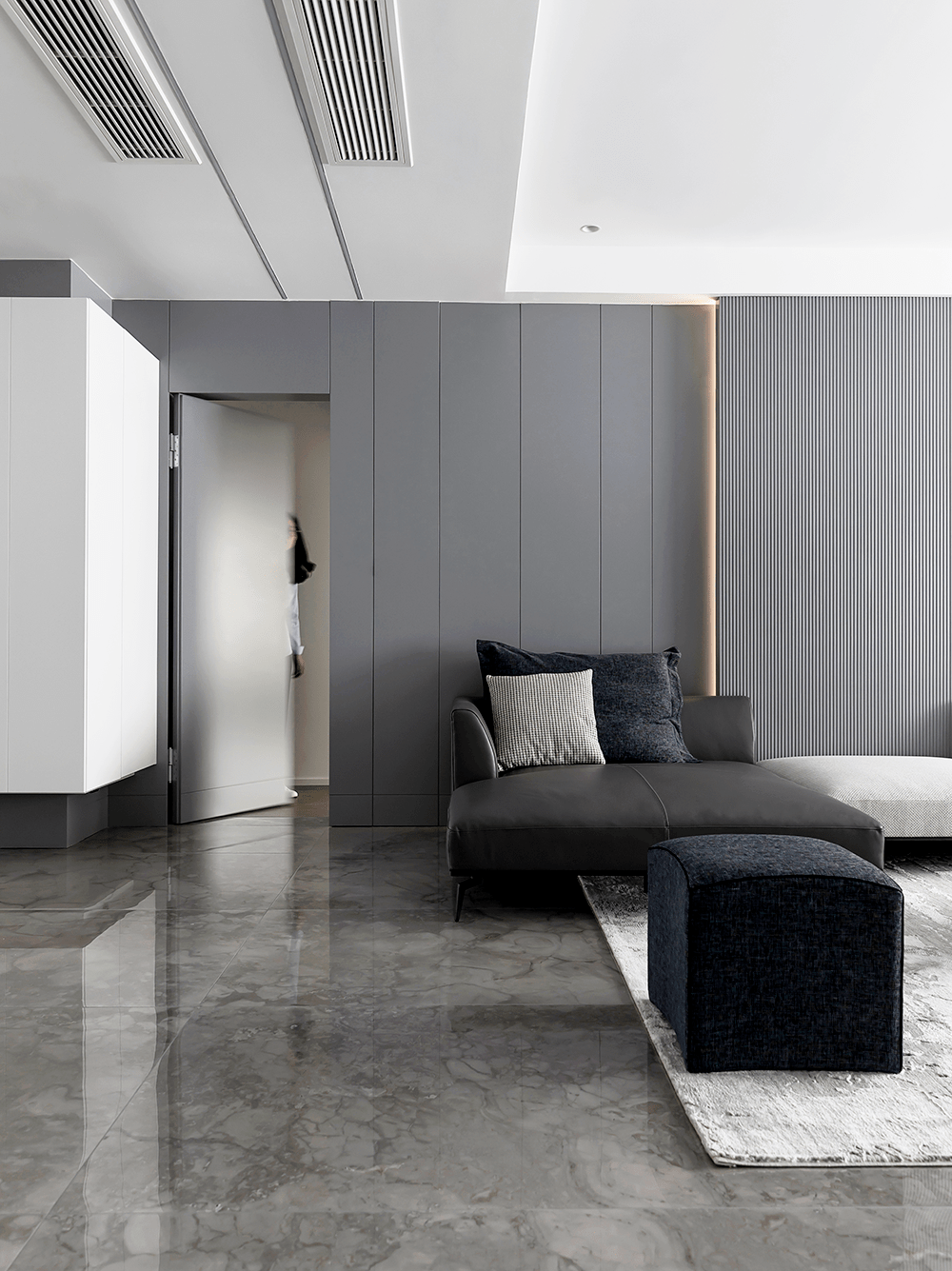 白色悬挂盒体与灰色墙面相接,白色的柜门下藏着男女主人烟火气的生活.