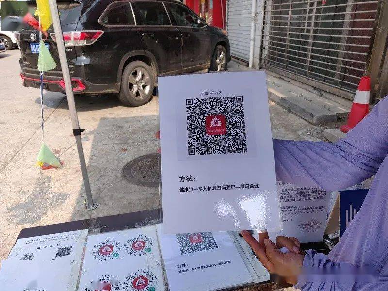 为方便居民扫码,社区制作了手持式北京健康宝二维码牌,放在卡口登记桌
