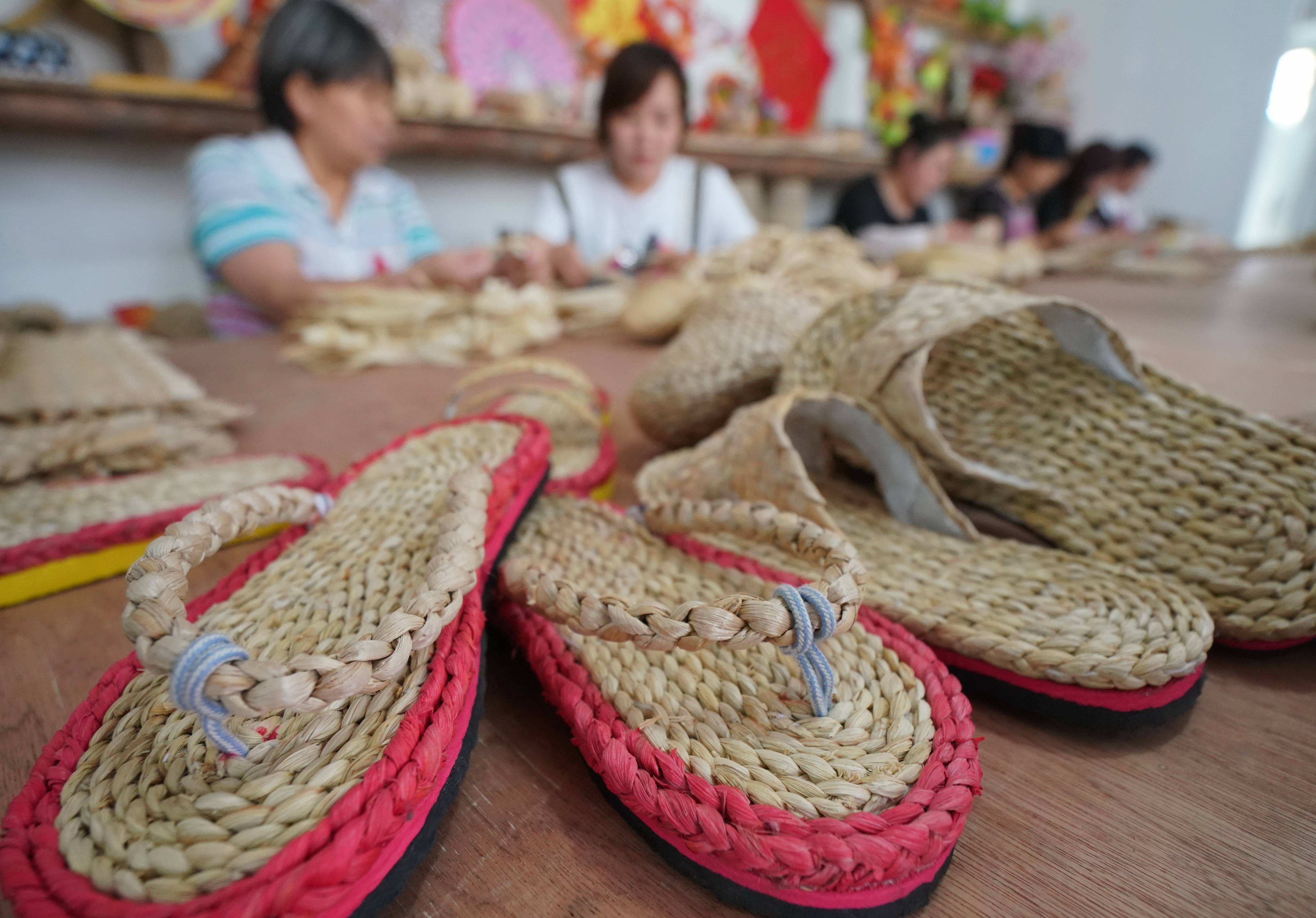 7月15日,秦皇島市撫寧區撫寧鎮的婦女在孤竹園草編基地編制草編工藝品