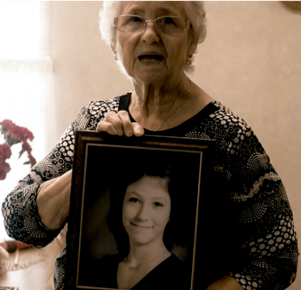 南希的母亲埃琳·彼得森抱着女儿的遗像