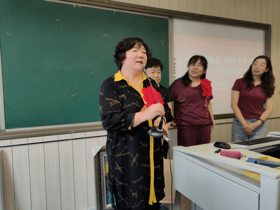 为退休教师献上丁可老师的作品留念校领导为她们佩戴大红花,并颁发