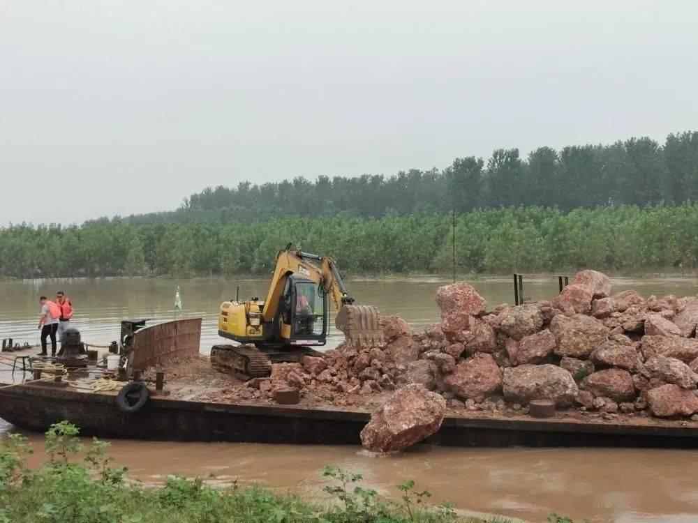 机将第一块大石从运输船上抛入水中,大口村抱鸡母洲段崩岸险情抛石镇