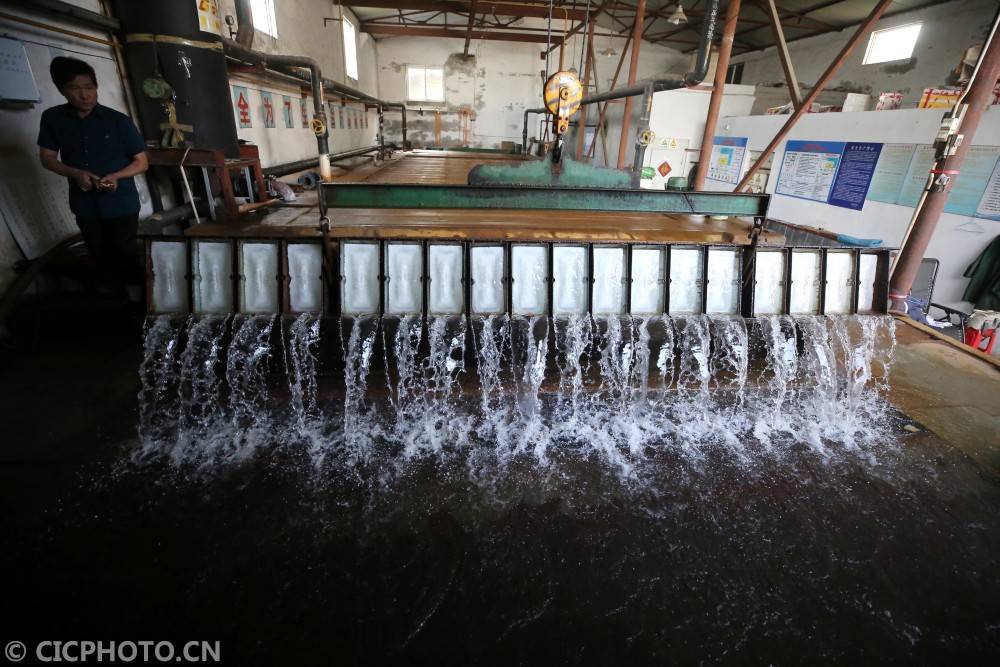 2020年8月1日,在江苏省泰州市海陵区一家制冰厂,工人准备从制冰箱里