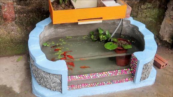 小哥自己在空地上用水泥做鱼缸造型精美能养鱼能种花创意好