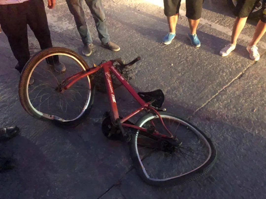 左车轮底下压着一辆严重损坏的自行车,富横中路路口的斑马线附近,看到