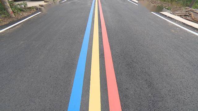 发现,整条道路变得宽敞平整,路中间还设置了红黄蓝三色组成的彩虹标线
