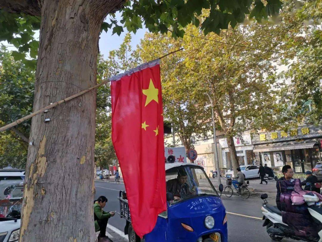 发现这里有不少商户和单位的 门前悬挂了国旗, 悬挂形式多样: 有的