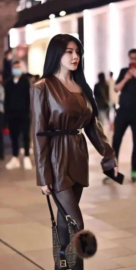 轻松演绎出皮裙美女的时尚魅力,引起周围路人拍照,让她有着时尚模特的