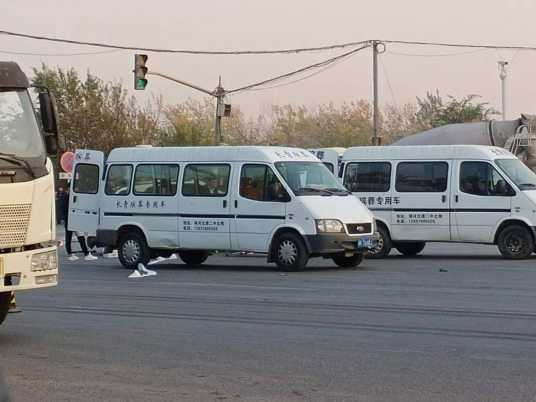 长青殡葬两辆运尸车赶到现场事故现场两位伤者被盖上蓝布下面是事故