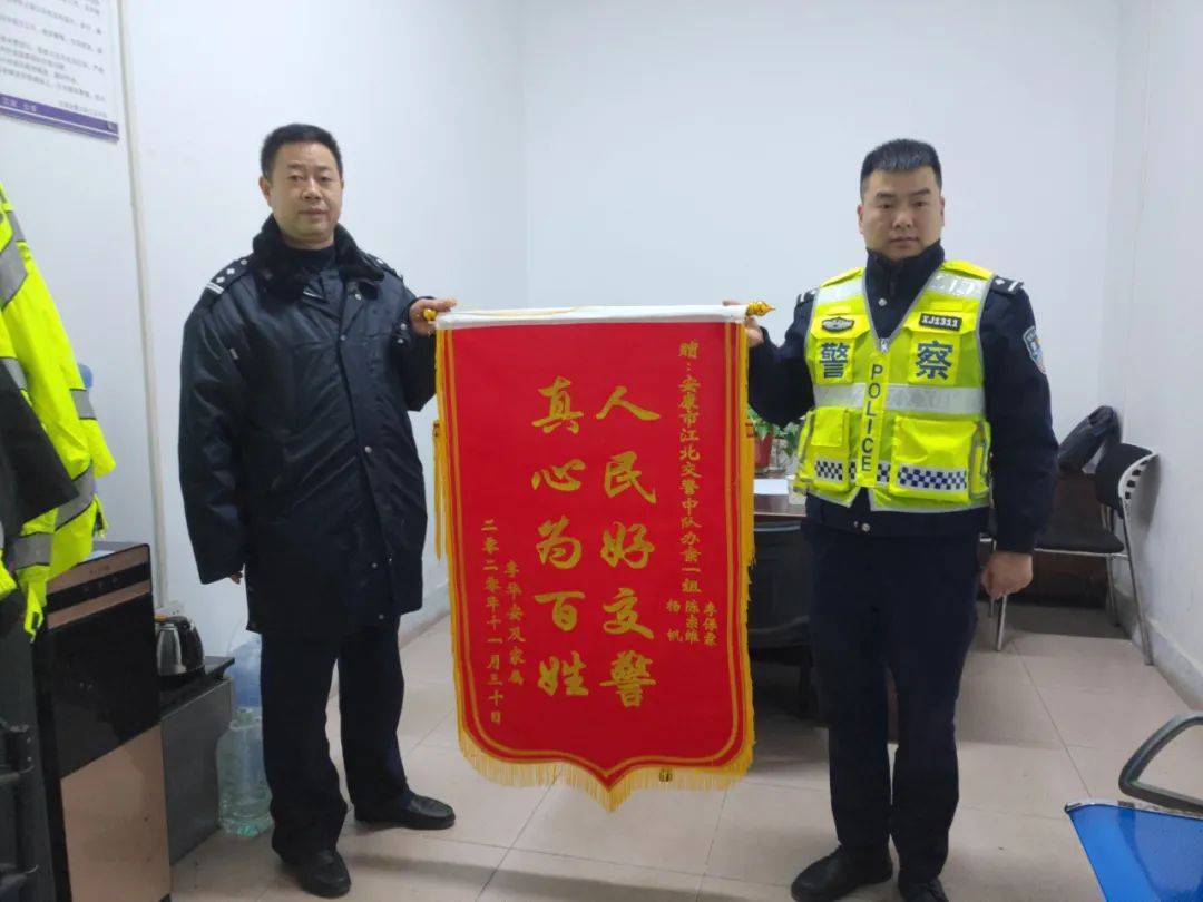 李先生为江北交警中队送锦旗"那天雨下得大,我被一辆三轮车撞倒在地上