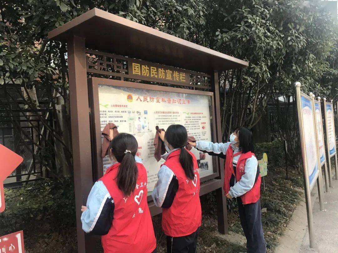 同学们手持垃圾夹,分工协作,清除草丛和道路上的垃圾,擦拭广告牌上的