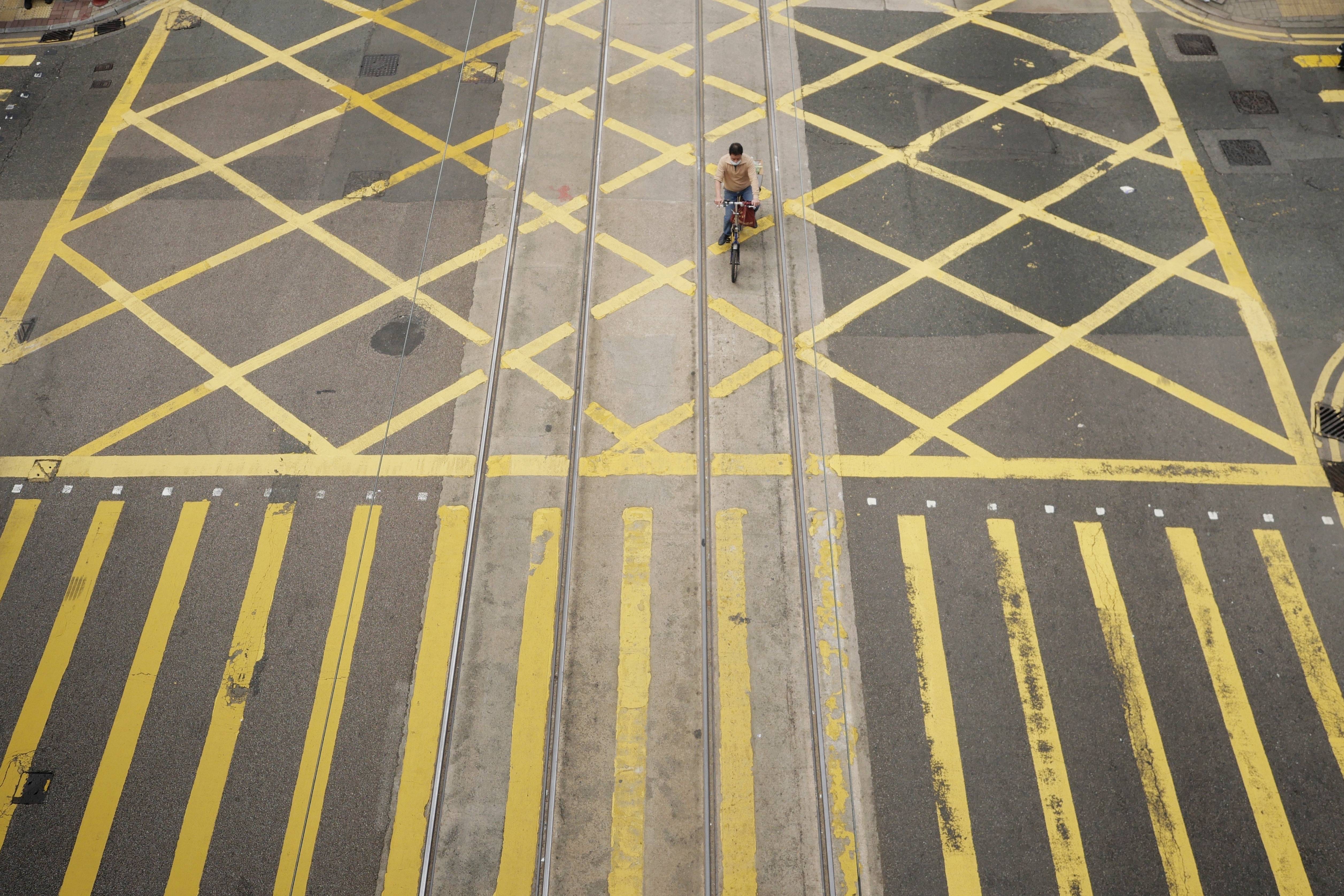 2021年1月4日,在香港中环,男子骑自行车经过十字路口