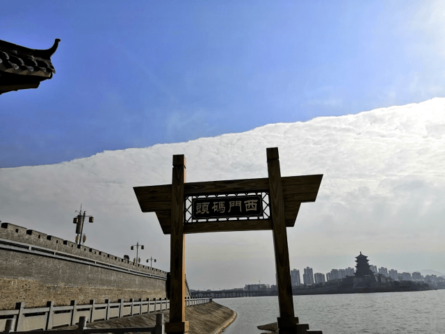 天空被雲層分割,將天空南北一分為二,北面朝陽一側熠熠生輝,萬里無雲